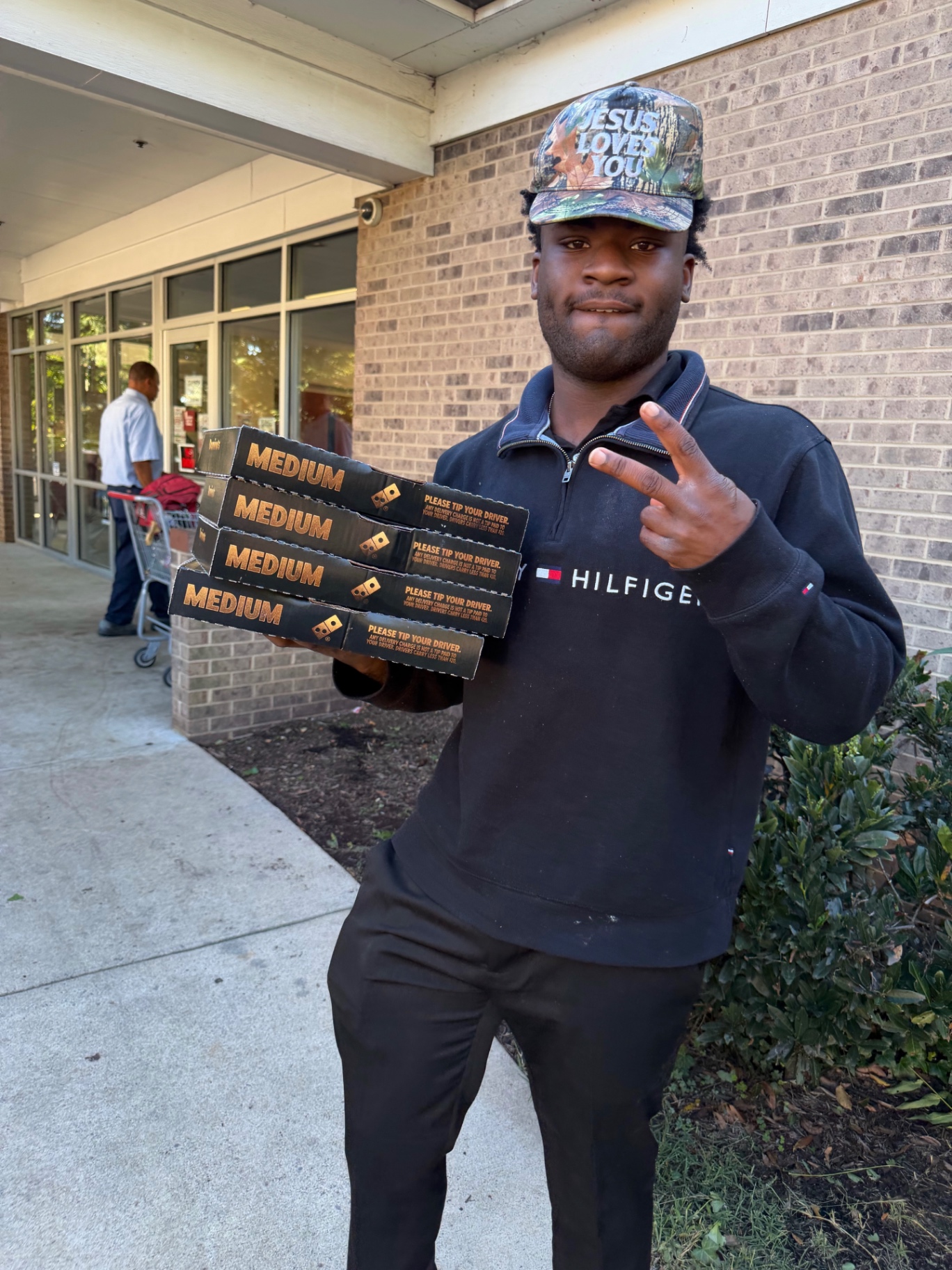 Daniel holding pizza boxes outside a building