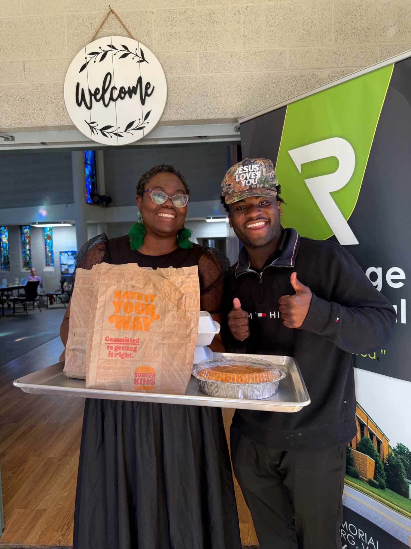 Daniel and a woman smiling with a tray of food