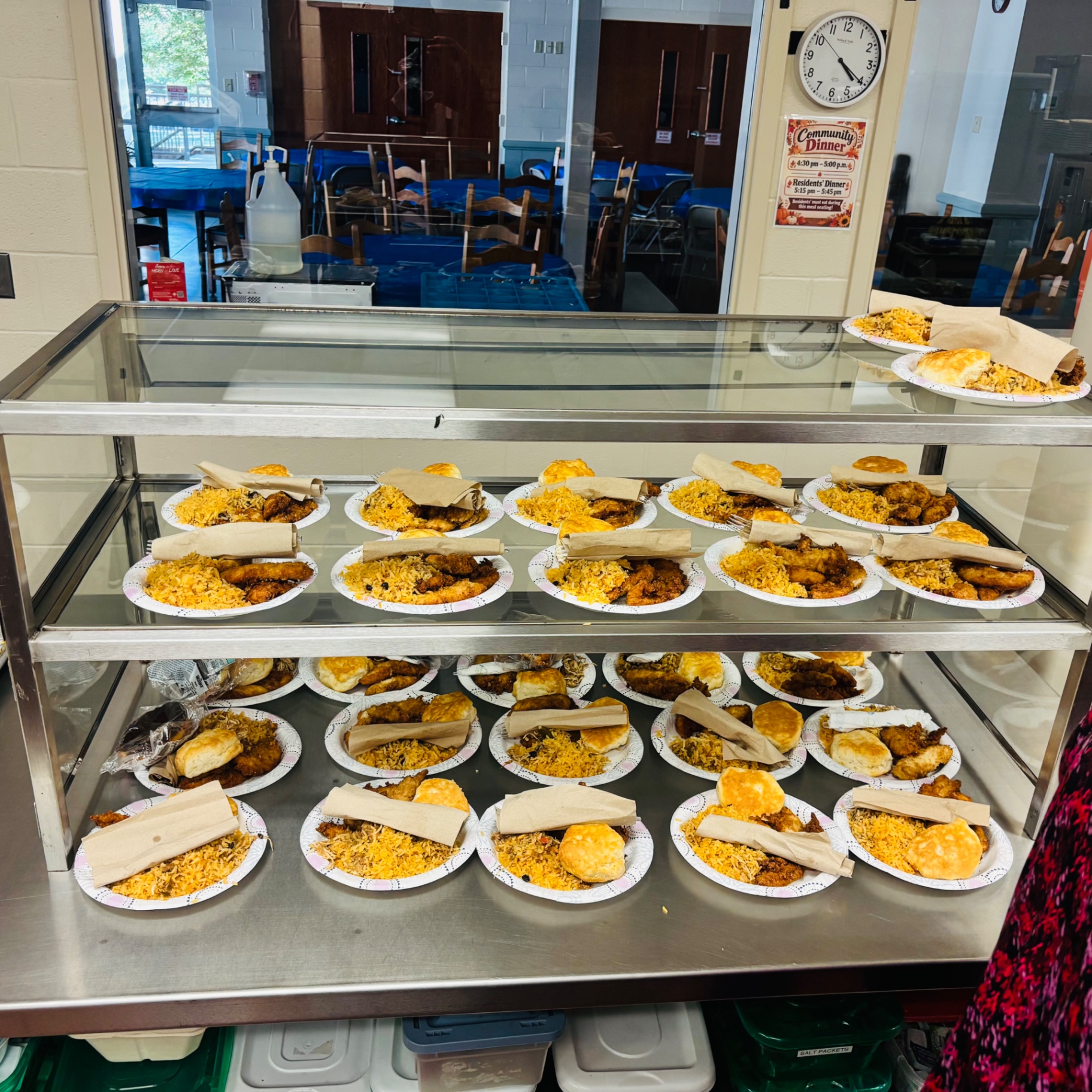 Serving counter filled with plated dinners including chicken nuggets and tacos