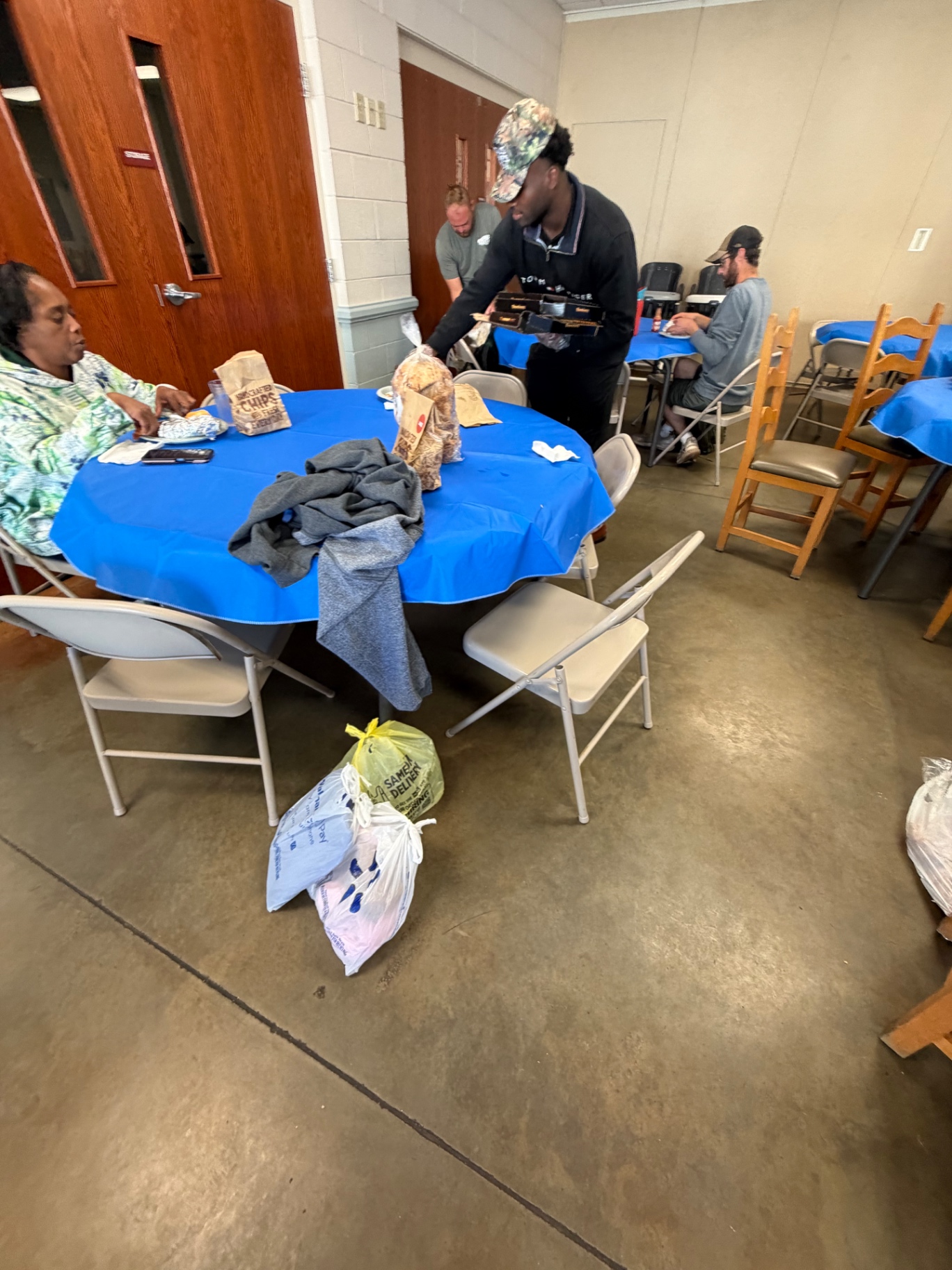 Daniel sharing food with people seated around a table